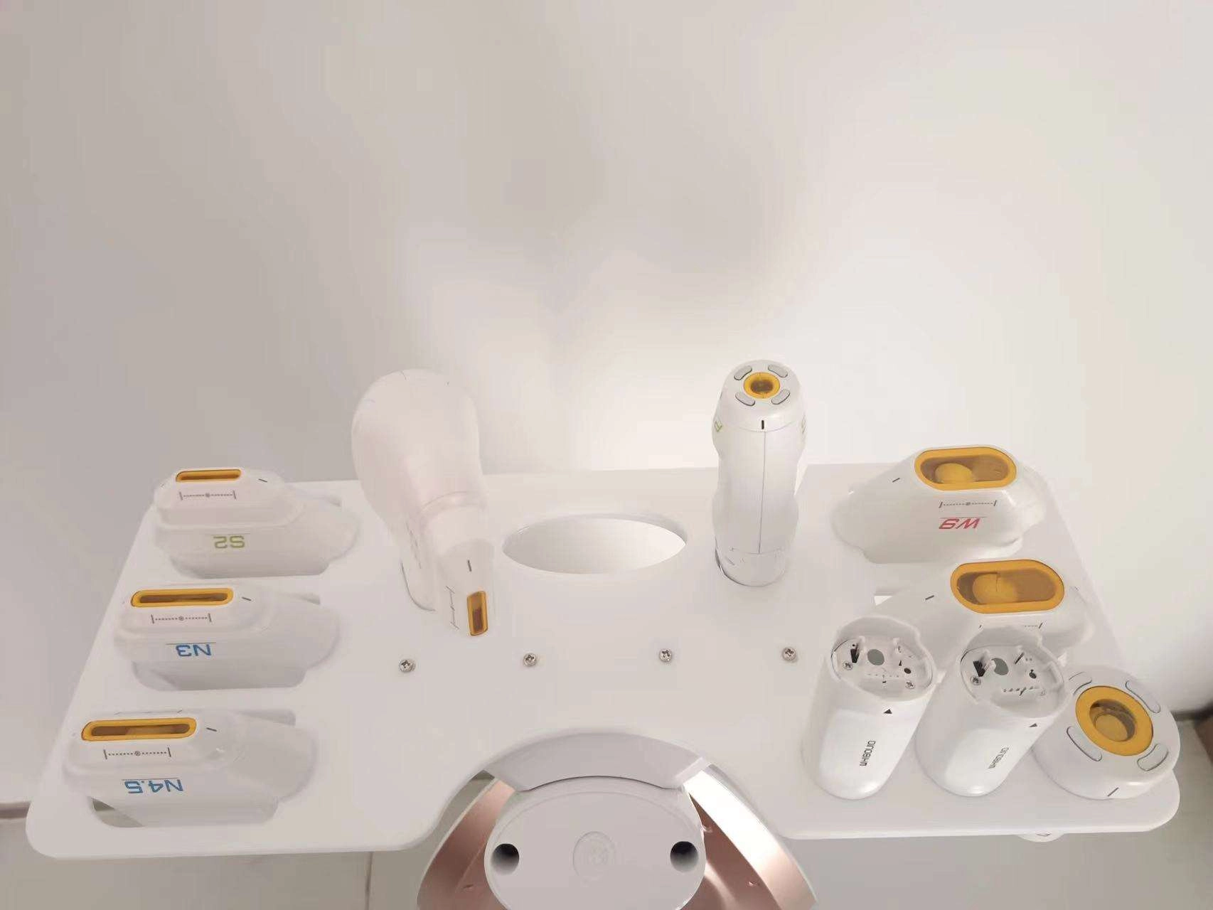 Beauty device attachments on a white stand. - HUIMAIN